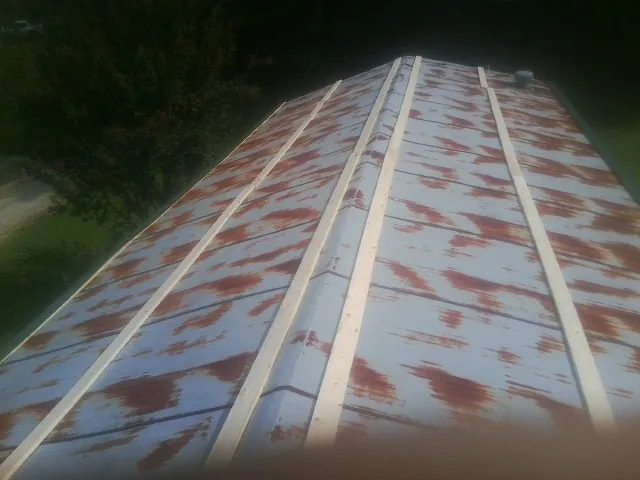 Rusted metal roof panels with new wood purlins before replacement — Storm Damage Roof Repair in Wickenburg by Roofing Brothers